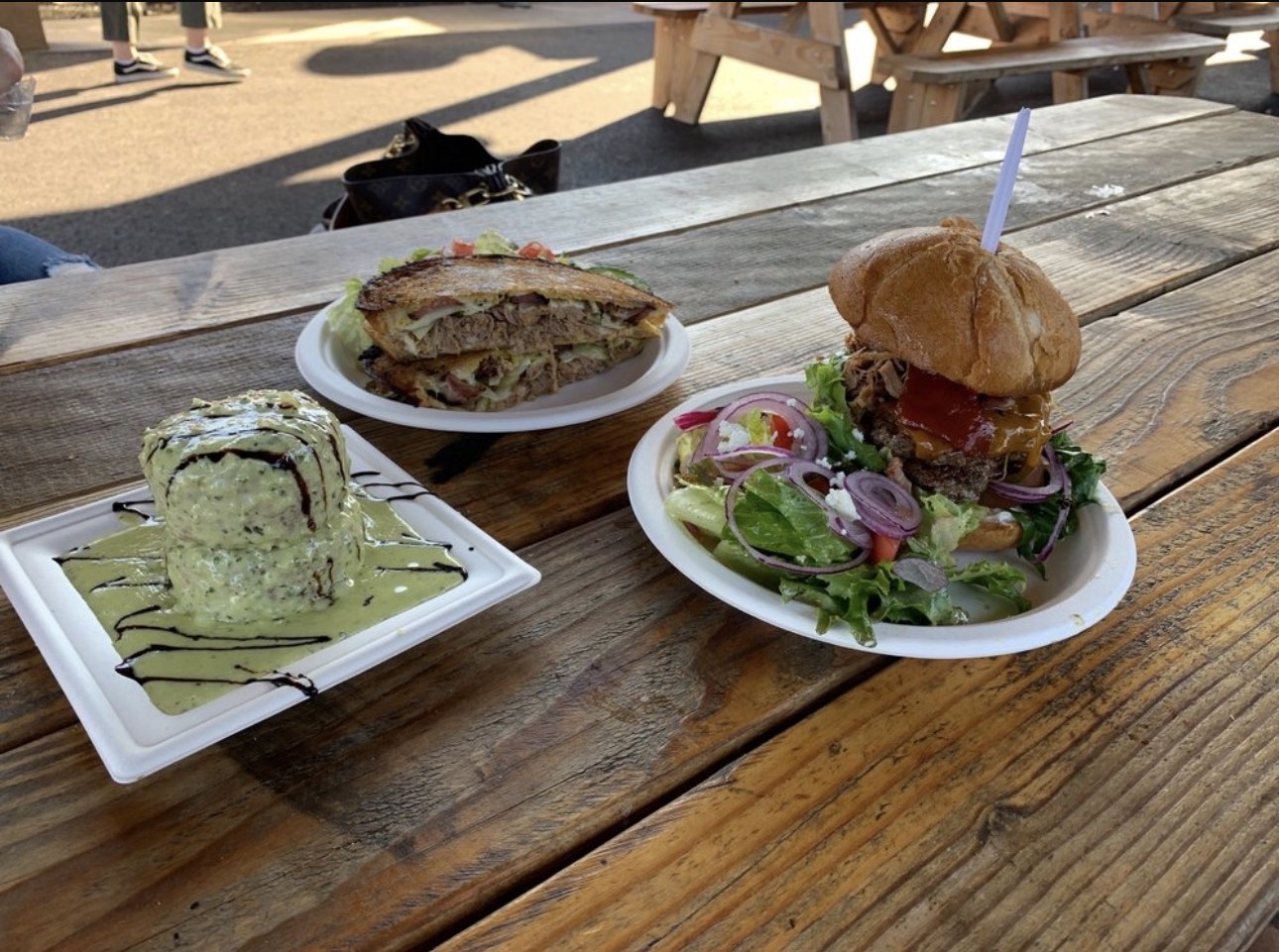 Risotto cakes, Cubano and stacked #99 burger on a picnic table